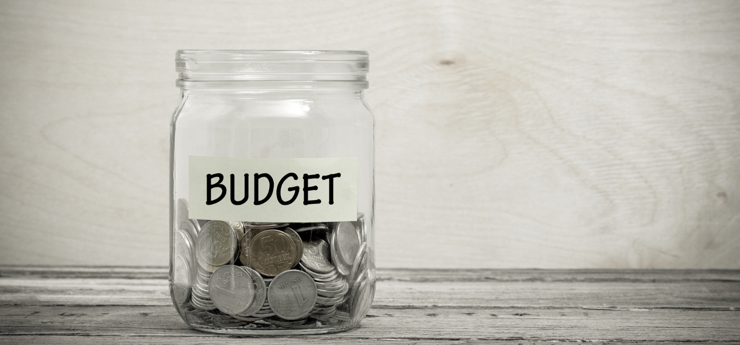 玻璃罐裡裝著硬幣,標籤寫著「BUDGET」