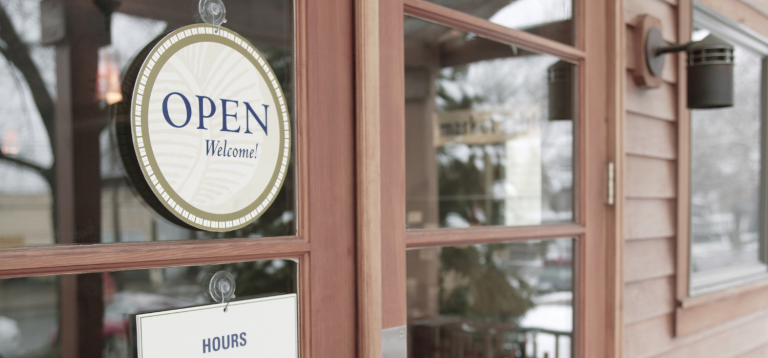 玻璃門上掛著「OPEN Welcome」營業牌，下方有營業時間告示