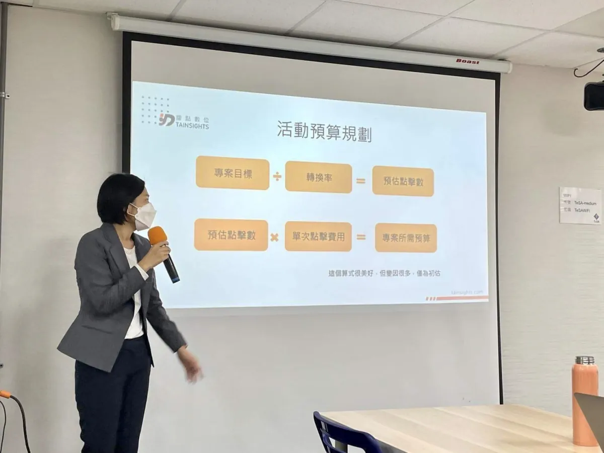 講師手持麥克風,以「活動預算規劃」投影片說明預算與點擊的估算方式